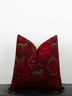 a red pillow sitting on top of a black table