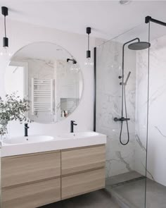 a bathroom with two sinks and a large mirror on the wall next to the shower