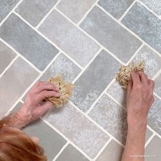 an older woman is cleaning the floor with a sponge and a rag on her hands