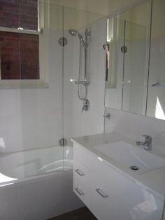 a bathroom with a sink, mirror and bathtub