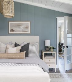 a bedroom with blue walls and white furniture