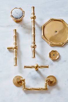 gold bathroom accessories laid out on a marble counter top