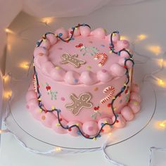 a pink birthday cake with decorations on it