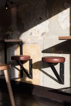 three wooden stools sitting next to each other