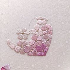 some pink and white flowers on a white surface with small circles in the middle that have been stitched together