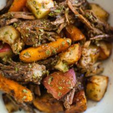 a white bowl filled with meat and veggies