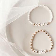 the bride and groom bracelets are made from pearls with gold beaded letters on them