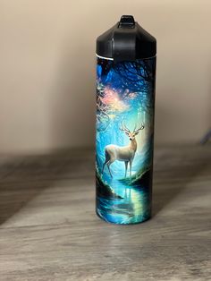 a water bottle sitting on top of a wooden table next to a blue and white painting