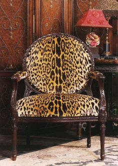 a leopard print chair sitting next to a lamp