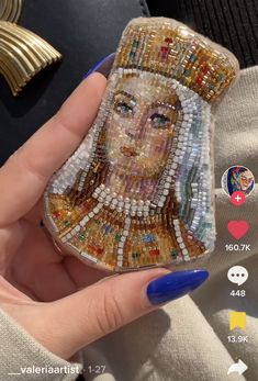 a woman's hand holding up a cell phone case with an image of the queen of england on it