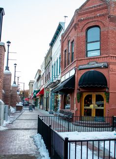 an old red brick building on a snowy street