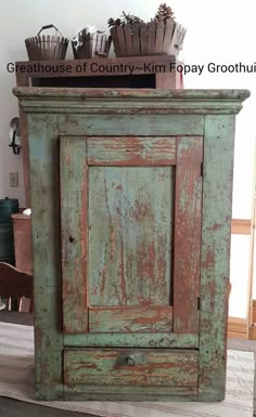 an old green cabinet is sitting on the floor