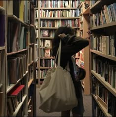 a woman carrying a bag through a library filled with books