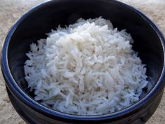 white rice is in a black bowl on the ground