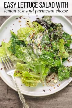 a white plate topped with lettuce covered in seasoning next to a fork