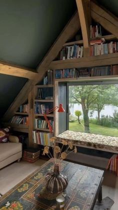 a living room filled with furniture and a book shelf next to a window covered in books