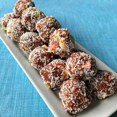 a white plate filled with chocolate covered donuts on top of a blue table cloth