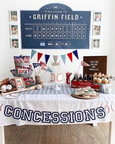 a baseball themed table with an american flag banner and cupcakes on the table