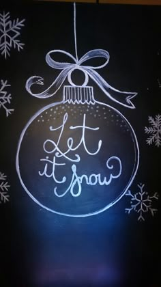 a chalkboard drawing of a christmas ornament with the words let it snow