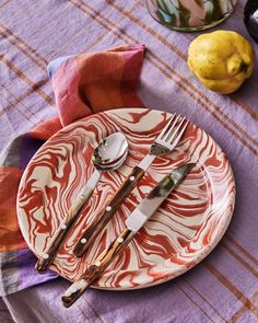 a plate with utensils on it sitting on a table next to lemons