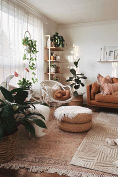 a living room filled with lots of furniture and plants on top of a rug in front of a window