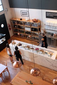 people are standing in the kitchen area of a restaurant