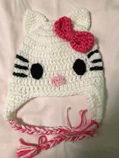 a crocheted hello kitty hat with a pink bow