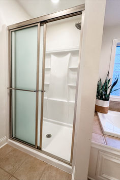 a bathroom with a walk in shower next to a bath tub