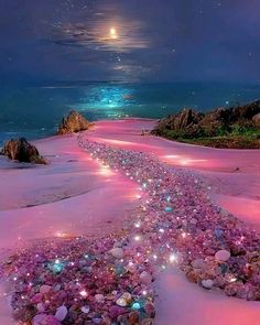 an image of a beach at night with rocks and stars