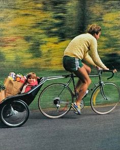 a man riding a bike with a baby in the back