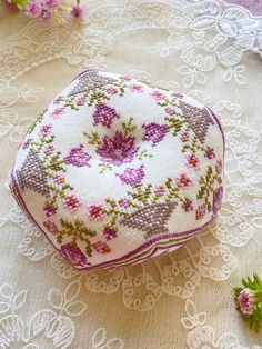 a close up of a piece of fabric with flowers on the table next to it