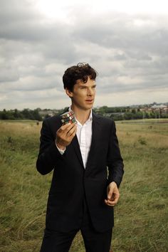 a man in a suit is holding a small object