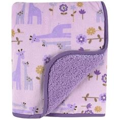 a purple blanket with giraffes and flowers on it