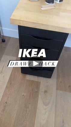 an ikea drawer is on the floor next to a table with cups and mugs