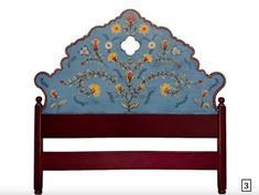 a blue headboard with flowers and vines on it