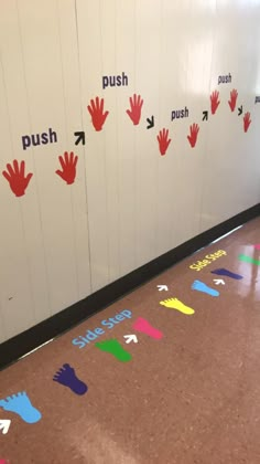 several hand prints on the floor in front of a wall with push, push, push and push signs