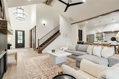 a living room filled with furniture and a fire place in front of a stair case