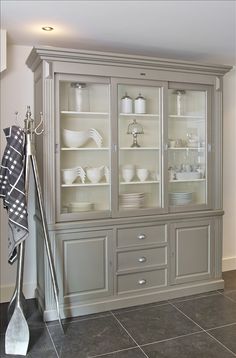 a large gray china cabinet with glass doors