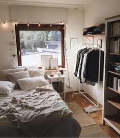 a bed sitting in a bedroom next to a book shelf with books on top of it