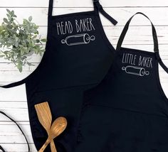 two aprons with the words read baker and little baker on them next to a wooden spoon