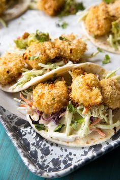 some tacos are sitting on a plate with lime wedges and cilantro