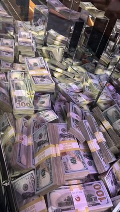 stacks of money sitting on top of each other in front of a glass display case