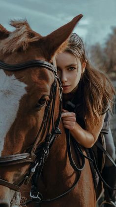 a young woman is riding on the back of a brown and white horse with her hand on it's bridle