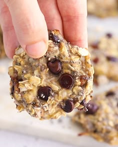 a person picking up an oatmeal cookie