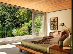 a bedroom with a large bed sitting next to a sliding glass door that leads outside