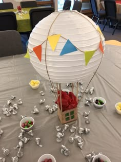 a table topped with bowls and plates filled with fruit next to a hot air balloon