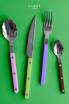 three forks, two spoons and one knife on a green surface