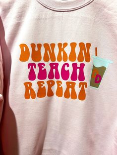 a pink sweatshirt with the words dunkin'teach repeat on it