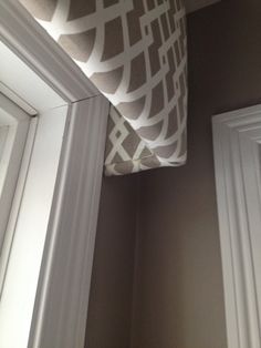 a close up of a pillow on a window sill in a room with white trim