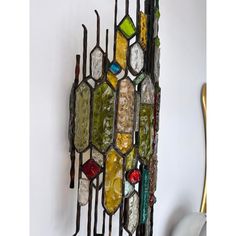 a multicolored stained glass piece hanging on the wall